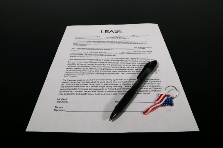 Lease agreement document with pen and American flag keychain on a black table.