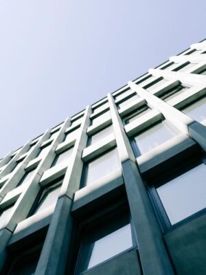 From below of contemporary design of facade of building with many windows under blue sky