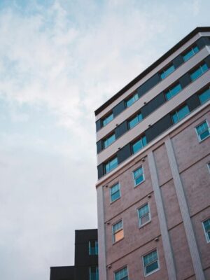 From below of contemporary high rise building with glass brick wall and windows windows under dusky sky
