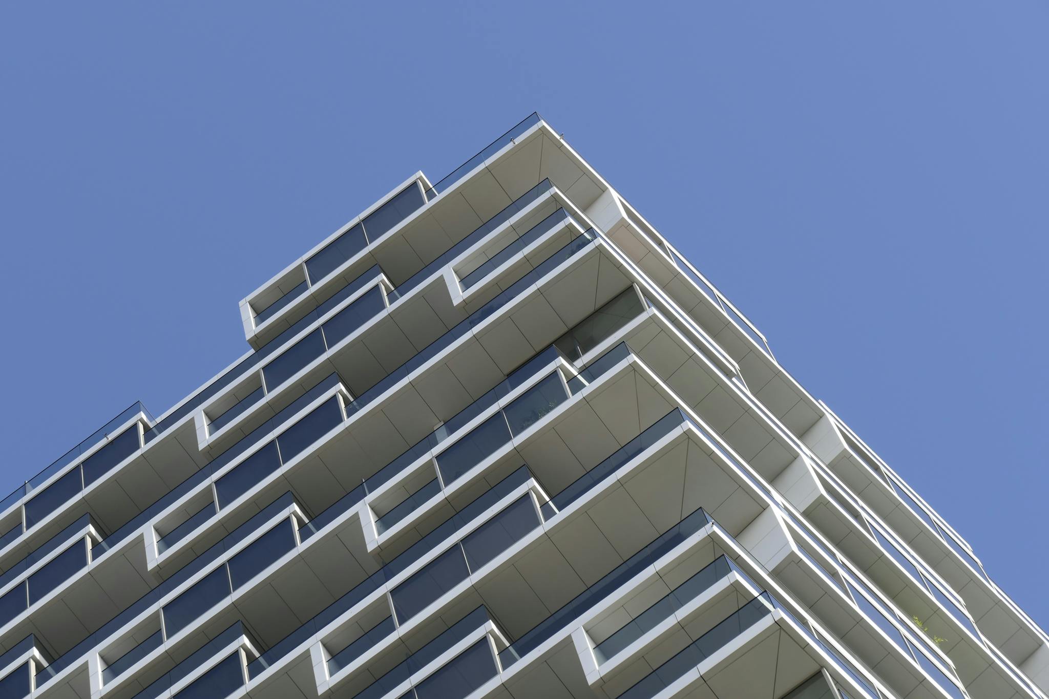 Low angle view of a sleek, modern apartment building in Frankfurt against a clear sky.